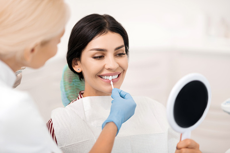 Dentist puts dental veneers patient and correction of teeth