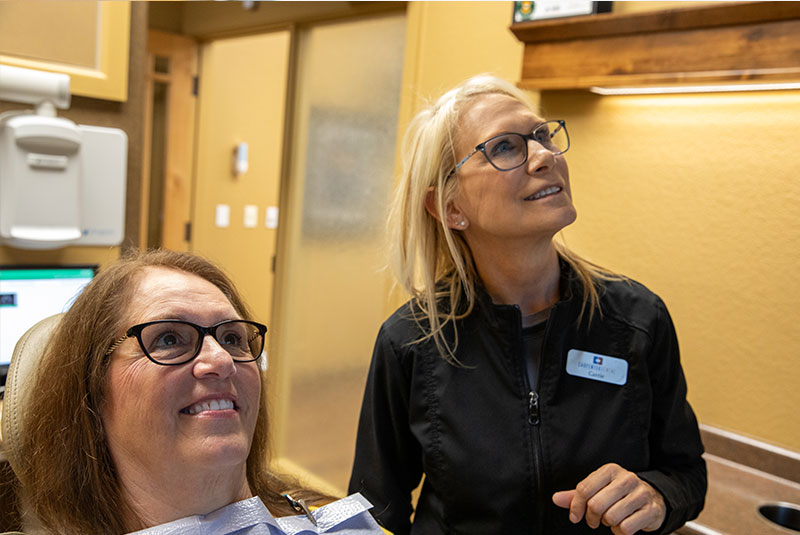 patient and doctor looking at display for dental procedure