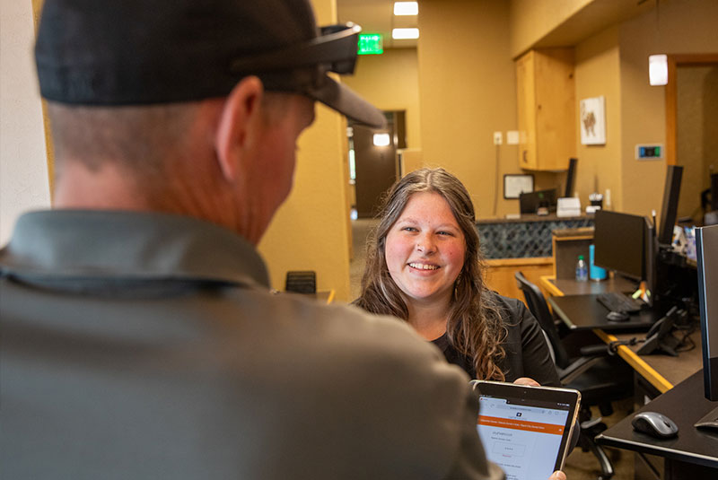 staff member helping patient at the front desk within the dental practice