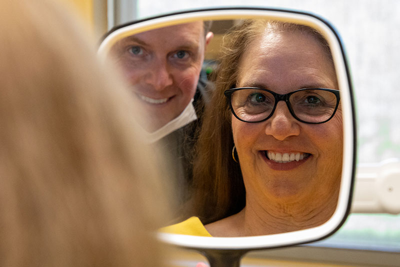 patient smiling at the mirror after their dental procedure