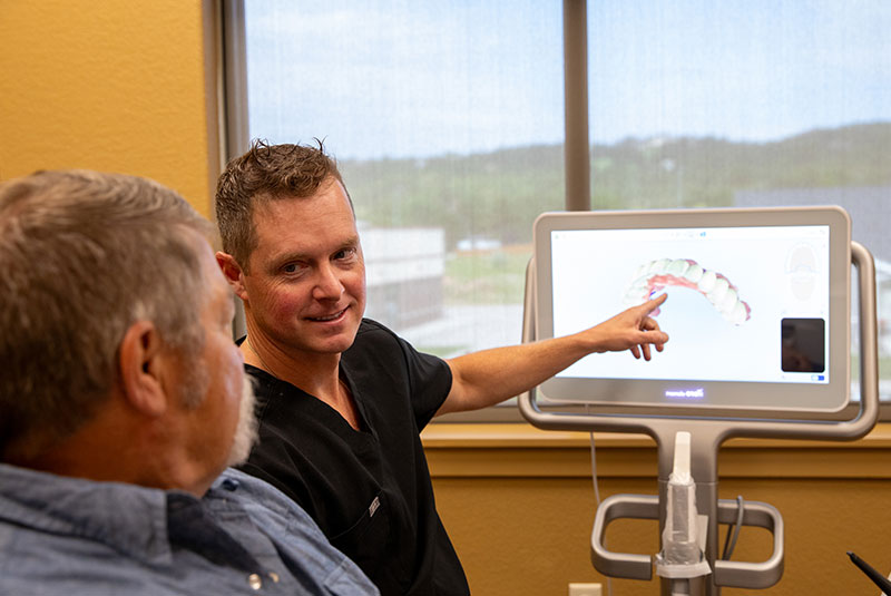 doctor and patient going over dental procedure information with display