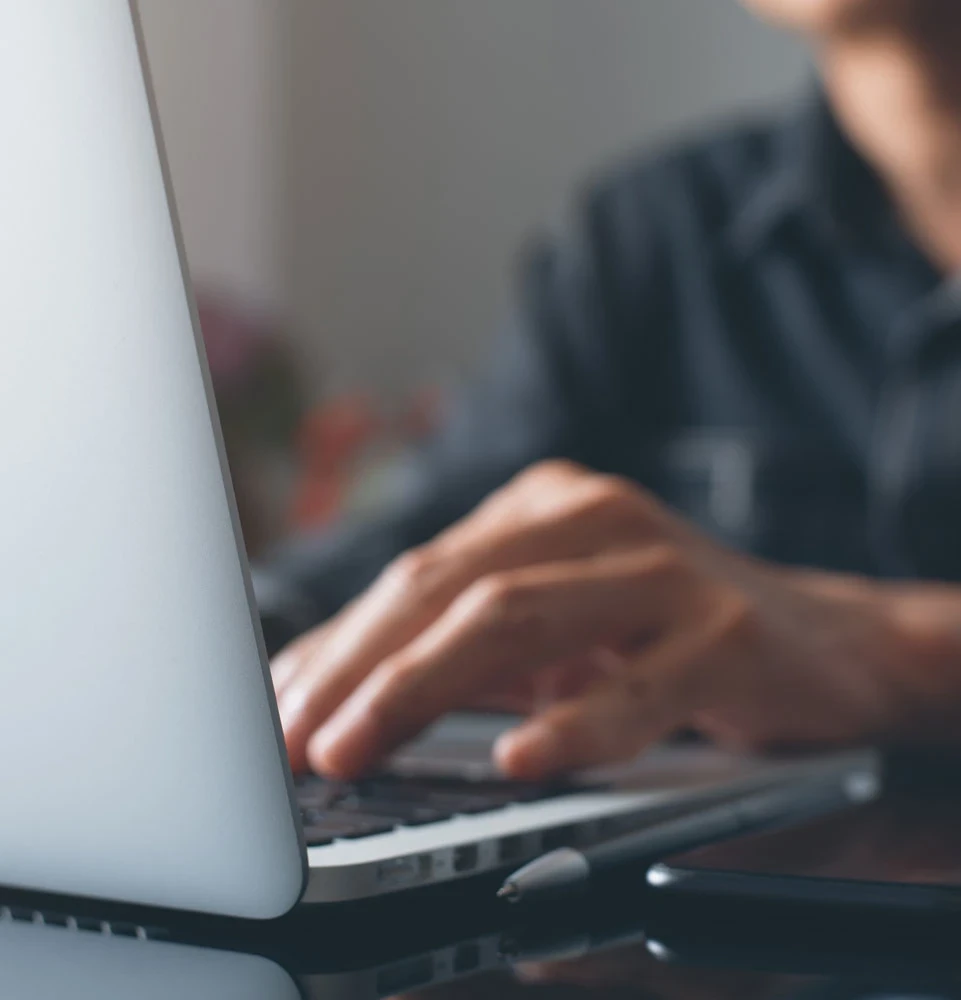 Guy typing into laptop to contact the dental office
